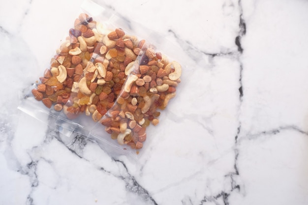 Photo close up of many mixed nuts in a packet on table