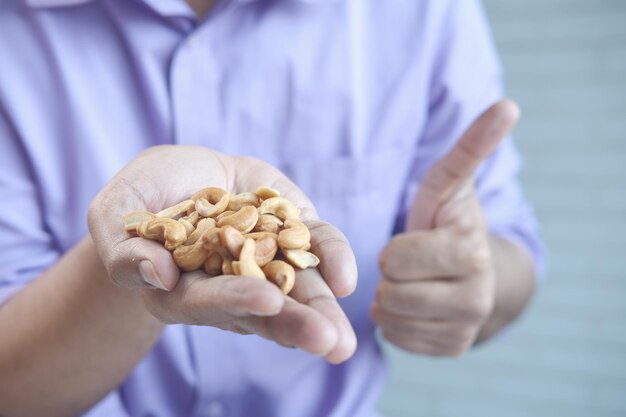 Photo close up of many mixed nuts on palm of hand