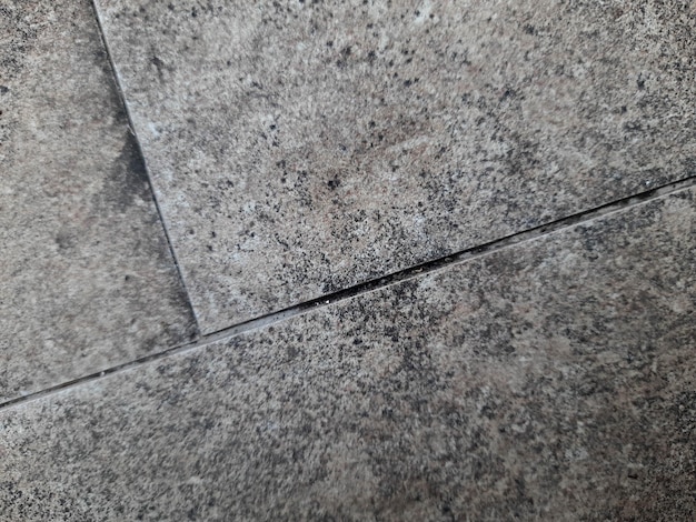 A close up of a marble floor with a crack in the middle.