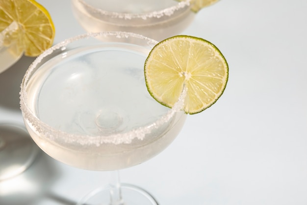 Photo close-up of margarita in glass with lime on white desk