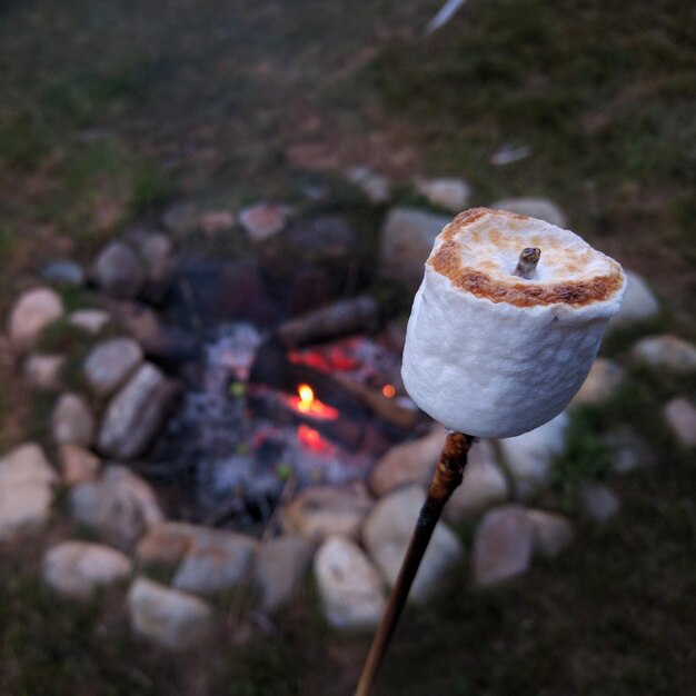 Photo close-up of marshmallow against bonfire