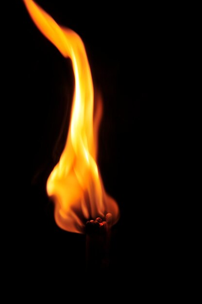 Photo close-up of matchsticks burning against black background