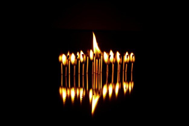 Foto close-up di fiammiferi che bruciano su uno sfondo nero