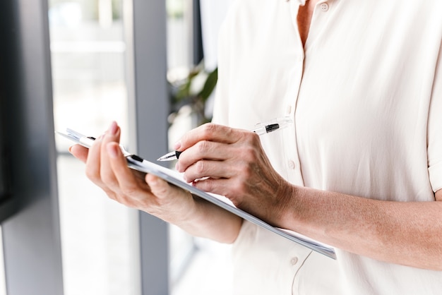 Close up of mature business woman taking notes