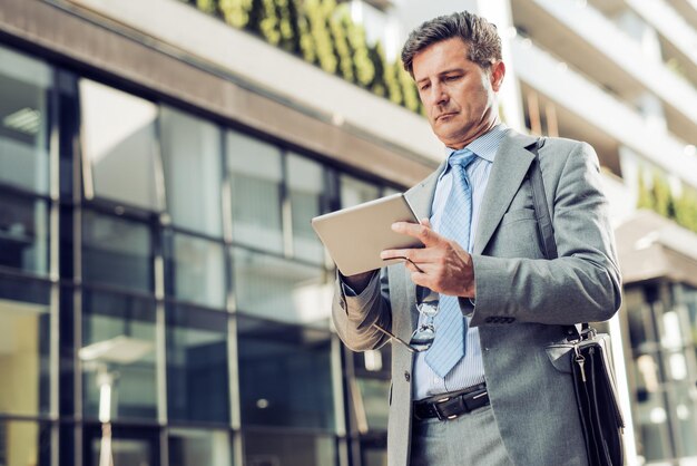 Close up of mature businessman using a tablet