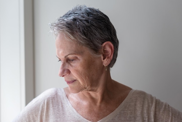 Close-up of mature woman against wall at home