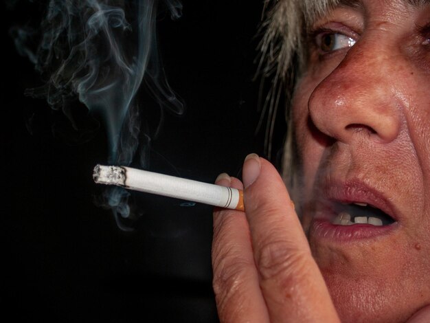 Photo close-up of mature woman smoking cigarette