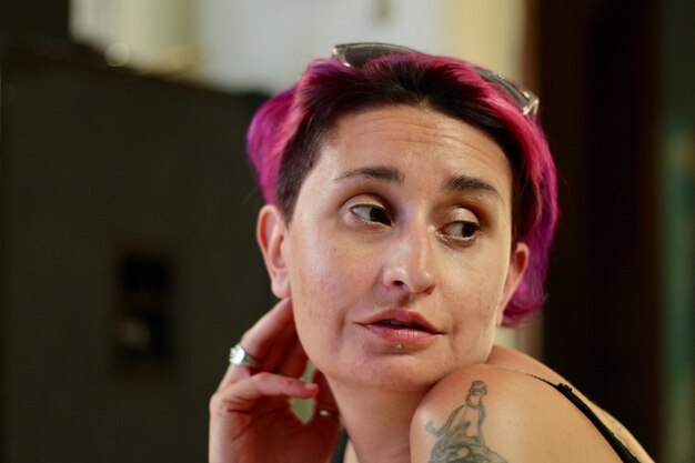 Photo close-up of mature woman with dyed hair looking away while sitting at home