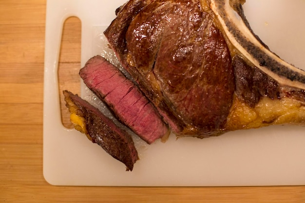 Photo close-up of meat in plate on table