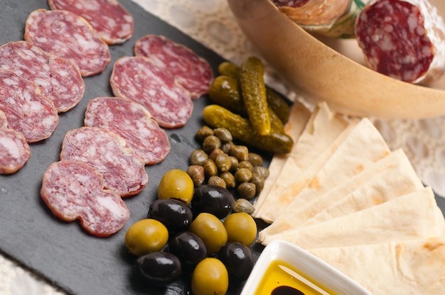 Foto close-up di carne con olive e pane servito a tavola