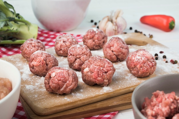 Foto polpette di close-up su tavola di legno con carne macinata