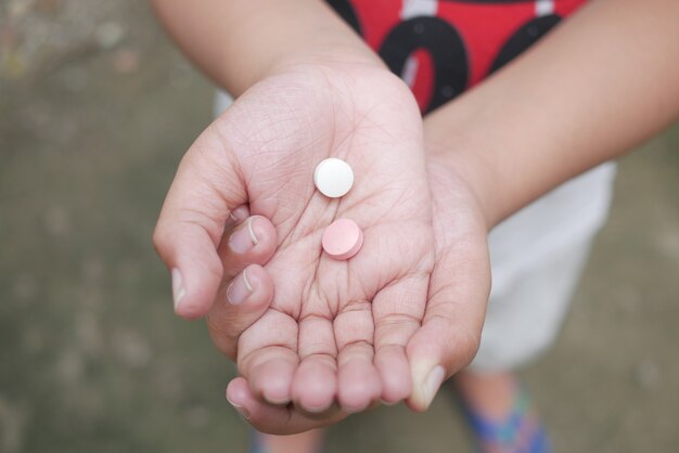 Primo piano di pillole mediche sul palmo della mano del bambino