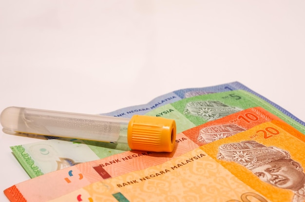 Close-up of medical supply on paper currency against white background