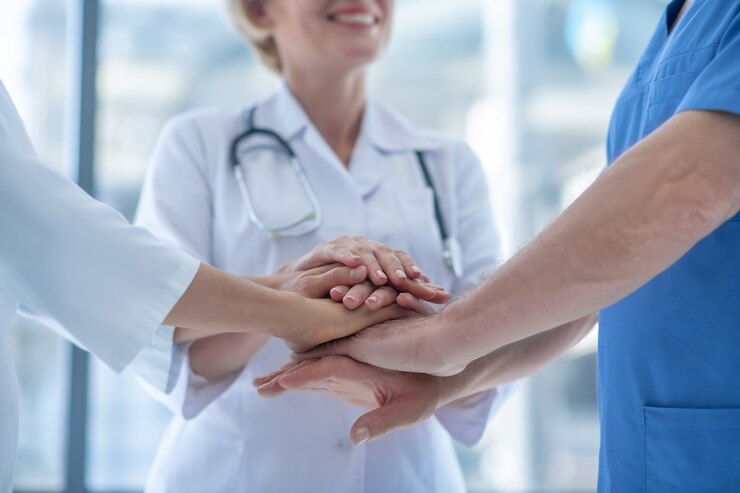 Photo close-up of medical workers with hands piled up