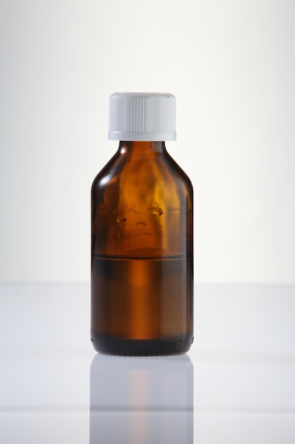 close-up of medicine in bottle on table against white background