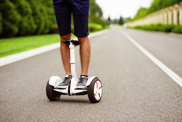 Avvicinamento. gambe da uomo in scarpe da ginnastica grigie su un giroscopio.