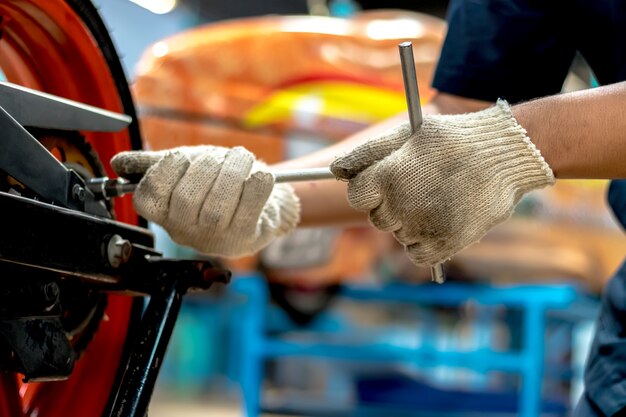 Close-up, mensen repareren een motorfiets Gebruik een moersleutel en een schroevendraaier om te werken.