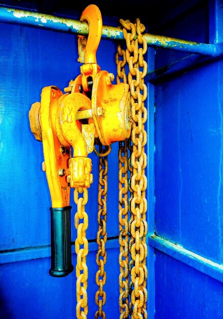 Close-up of metal chain against blue wall