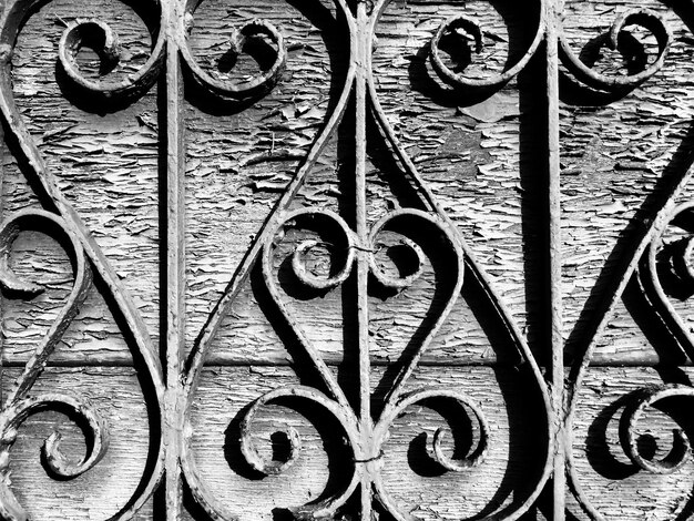 Foto close-up di una recinzione metallica contro un muro abbandonato