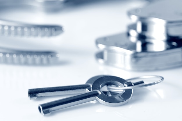 Close-up of metal keys to handcuffs isolated over white surface. Sexual games and practicing bdsm concept