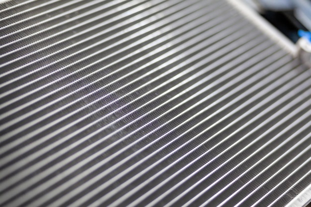 A close up of a metal sheet with lines of different sizes The texture of the car radiator