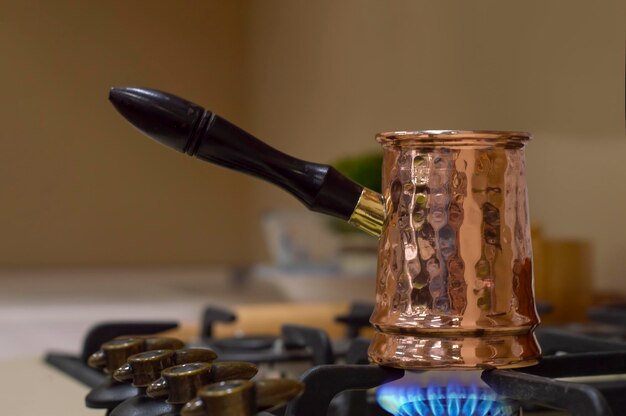 Photo close-up of metal turka  on gas plate