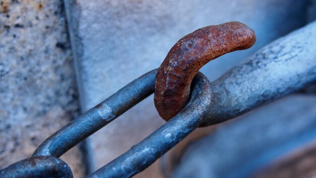 Photo close-up of metallic chain with rusty hook