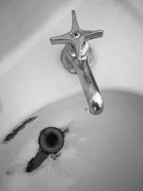 Close-up of metallic faucet in bathroom