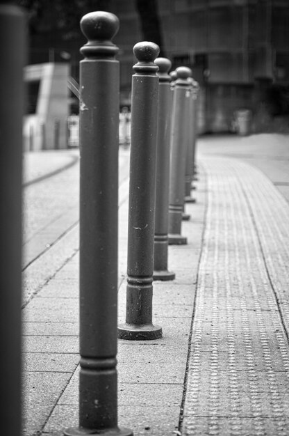 Photo close-up of metallic structure on sidewalk by building