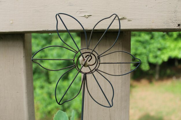 Photo close-up of metallic structure on wooden fence