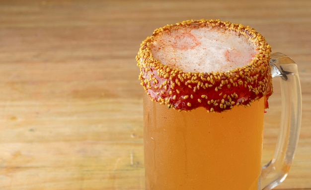 Close up of michelada in a jar with clear beer