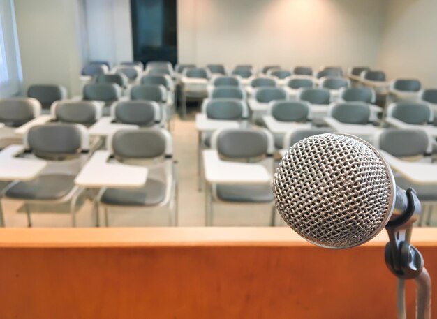 Close-up of microphone against empty chairs in lecture hall