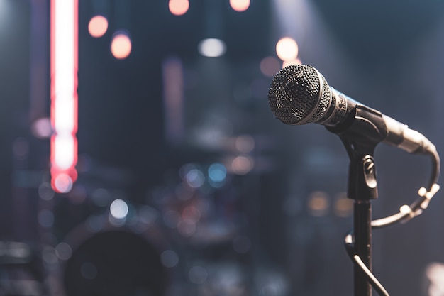 Photo close up of a microphone on a concert stage with beautiful lighting.