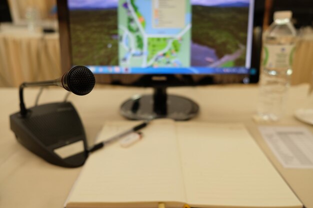 Photo close-up of microphone and desktop pc on desk in conference room