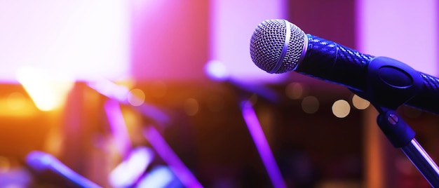 Close up of microphone on stage lighting at concert hall or\
conference room. copy space banner. soft focus.