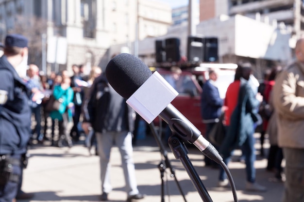 Close-up of microphone with people in background on street