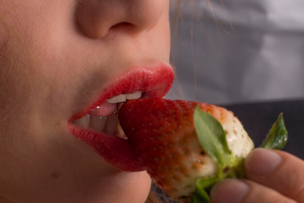 Photo close-up of mid adult woman eating strawberry