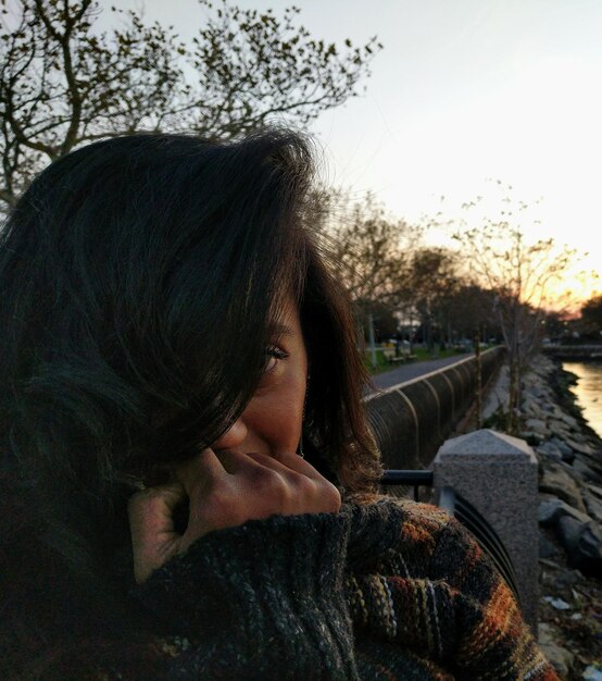 Photo close-up of mid adult woman standing by lake against sky during sunset