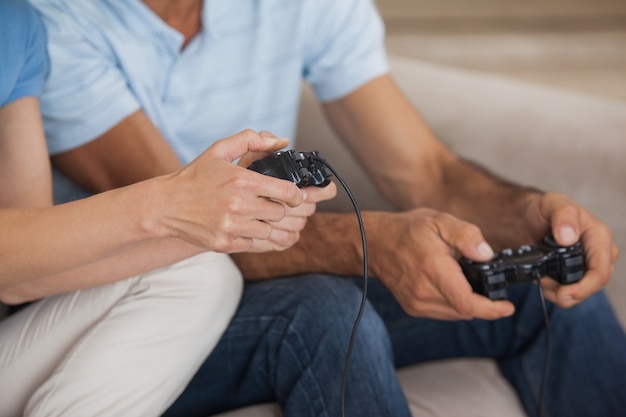 Photo close-up mid section of couple playing video games