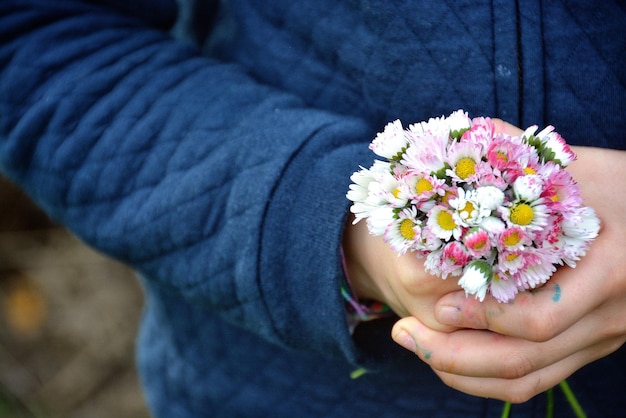 Close-up mid section of hands holding flowers