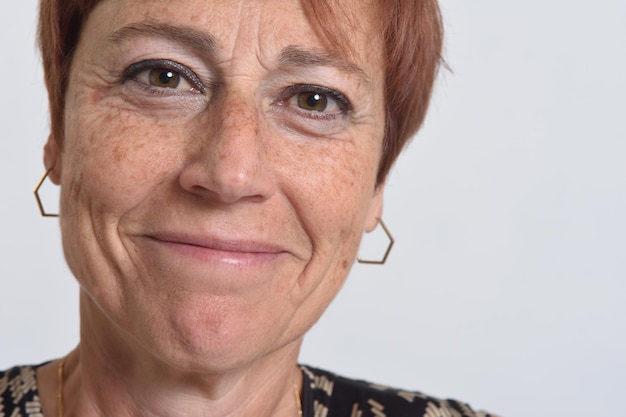 Close up of a middle aged woman smiling on white background