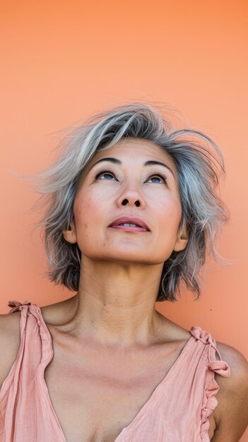 Close up of a middle aged woman with a peach copyspace background
