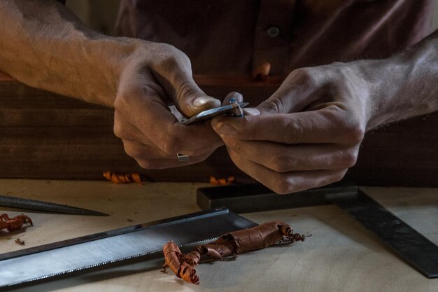 Photo close-up of midsection of carpenter sharpening pencil