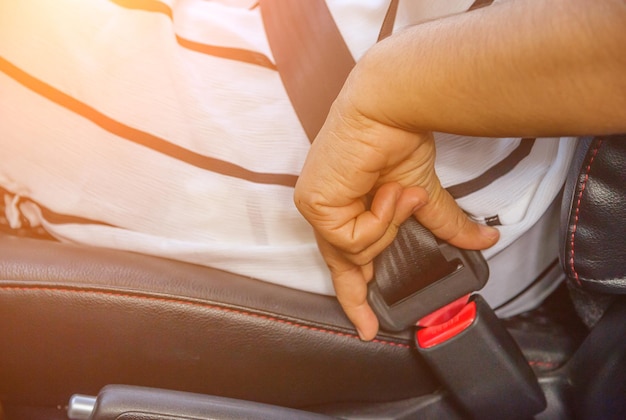 Photo close-up midsection of man fastening seat belt in car