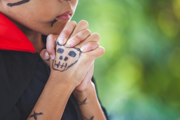 写真 ハロウィーンで海賊の衣装を着て祈っている女の子のクローズアップの中央部