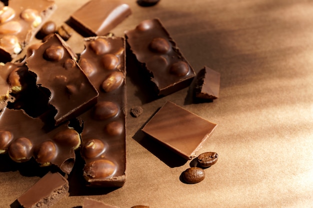 Крупным планом молочного шоколада с лесными орехами на коричневый