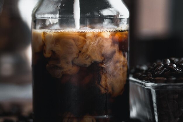 Photo close-up of milk pouring in coffee on table