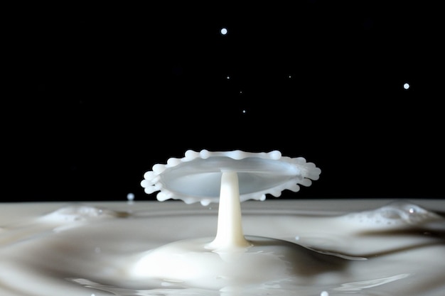 Photo close-up of milk splashing against black background