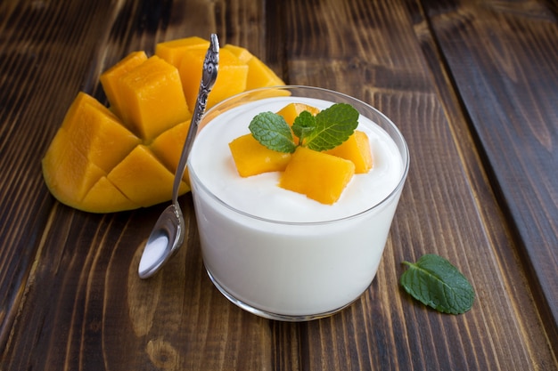 Close up on milk yogurt with mango in glass