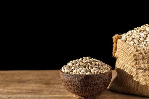 Close up millet rice or millet grains in small sack on wooden table